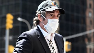 Michael Cohen returns home wearing mask.