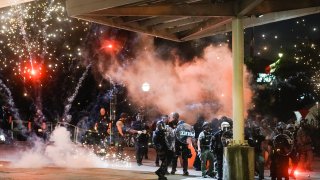 A firework explodes near a police line during a protest in response to the police killing of George Floyd on May 30, 2020 in Atlanta, Georgia.