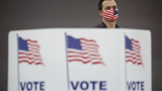 A poll worker wearing an American flag themed protective mask