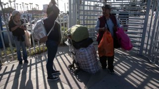 Migrantes esperan cruzar a EEUU en Tijuana para solicitar asilo.