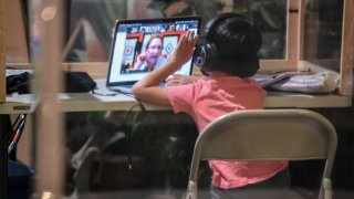 A student follows along remotely with their regular school teacher's online live lesson from a desk separated from others by plastic barriers at STAR Eco Station Tutoring & Enrichment Center on September 10, 2020, in Culver City, California.A student follows along remotely with their regular school teacher's online live lesson from a desk separated from others by plastic barriers at STAR Eco Station Tutoring & Enrichment Center on September 10, 2020, in Culver City, California.