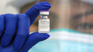 A nurse holds up a vial of the Pfizer coronavirus vaccine.