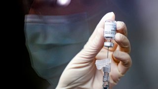 A pharmacy technician prepares a dose of the Johnson & Johnson COVID-19 vaccine for a clinical trial, Dec. 15, 2020, in Aurora, Colorado.