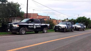 Un grupo de vehículos policiales resguarda el área donde mataron a siete personas