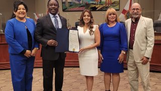 Olga Aymant junto a Jerry Demings y comisionados.