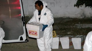 Peritos forenses trasladan restos humanos en hieleras