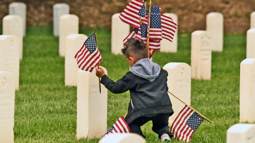 LOS ANGELES, CA – MAY 31:  Nathan Vigil but flags at veterans graves on Memorial Day veterans graves at Los Angeles National Cemetery May 31, 2021 in Los Angeles, California. (Photo by Nick Ut/Getty Images)