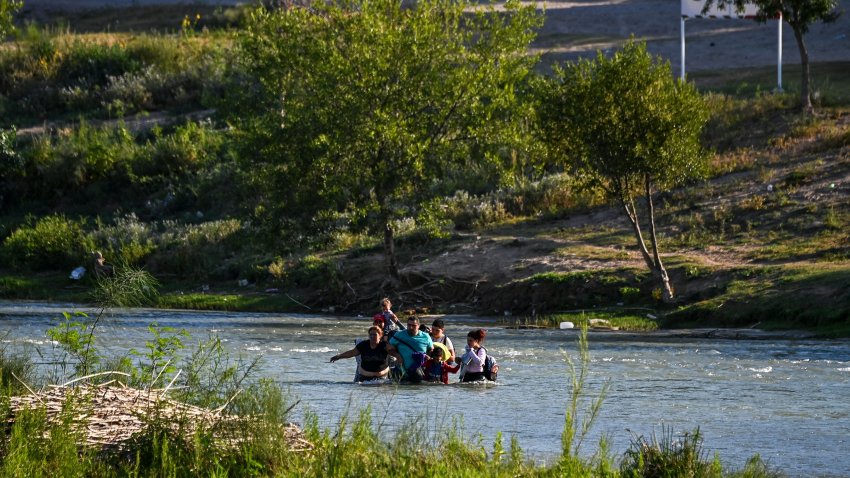 A migrant family from Venezuela illegally crosses the Rio Grande River in Eagle Pass, Texas, at the border with Mexico on June 30, 2022. – Every year, tens of thousands of migrants fleeing violence or poverty in Central and South America attempt to cross the border into the United States in pursuit of the American dream. Many never make it. On June 27, around 53 migrants were found dead in and around a truck abandoned in sweltering heat near the Texas city of San Antonio, in one of the worst disasters on the illegal migrant trail. (Photo by CHANDAN KHANNA / AFP) (Photo by CHANDAN KHANNA/AFP via Getty Images)