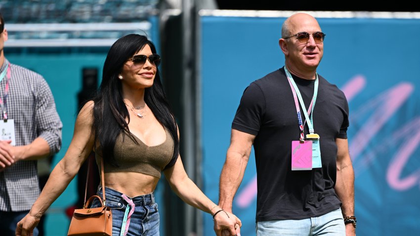 MIAMI, FLORIDA – MAY 06: Jeff Bezos and Lauren Sanchez walk in the Paddock prior to final practice ahead of the F1 Grand Prix of Miami at Miami International Autodrome on May 06, 2023 in Miami, Florida. (Photo by Clive Mason – Formula 1/Formula 1 via Getty Images)