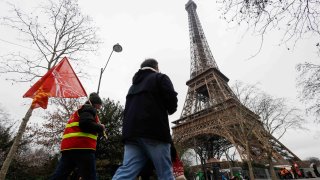 manifestantes protestan frente a la Torre Eiffel en París