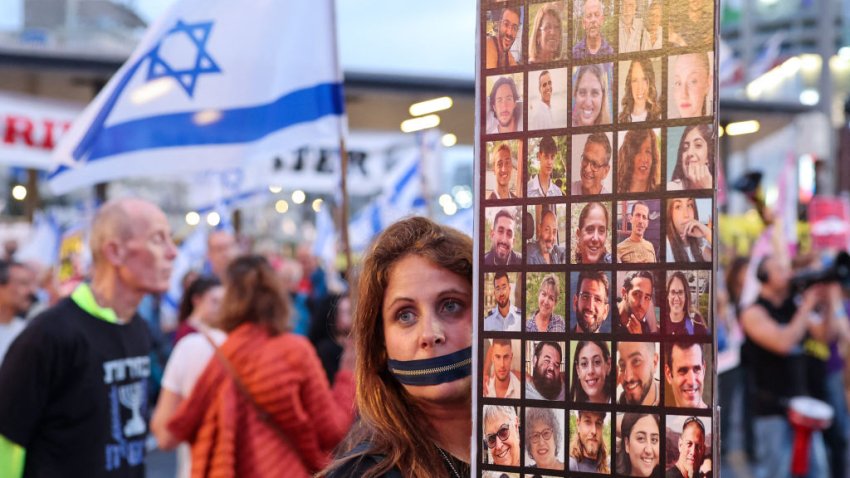 TOPSHOT – A protester with a zipper over her mouth, holds a placard showing pictures of Israeli hostages taken captive by Palestinian militants in Gaza during the October 7 attacks, during a demonstration calling for their release in the Israeli coastal city of Tel Aviv on April 27, 2024, amid the ongoing conflict between Israel and the militant Hamas group. (Photo by JACK GUEZ / AFP) (Photo by JACK GUEZ/AFP via Getty Images)