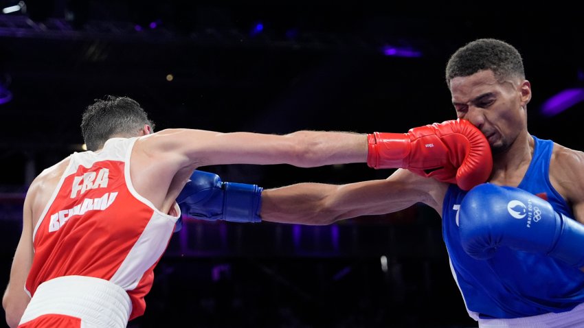 El dominicano Yunior Alcántara, de azul, intercambia golpes con el franc´s Billal Bennama en su combate de semifinales de peso mosca de Juegos Olímpicos, el domingo 4 de agosto de 2024, en Villepinte, Francia. (AP Foto/Ariana Cubillos)