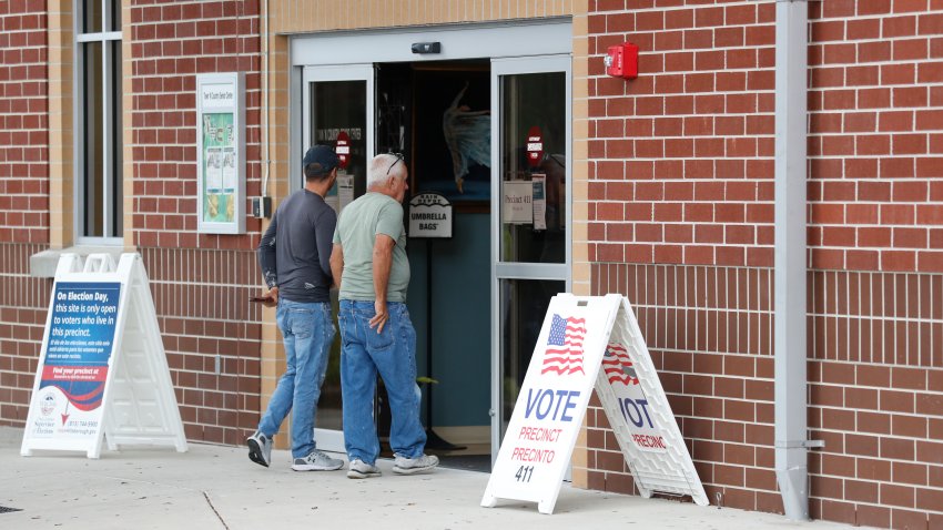 Two people walking into a polling location