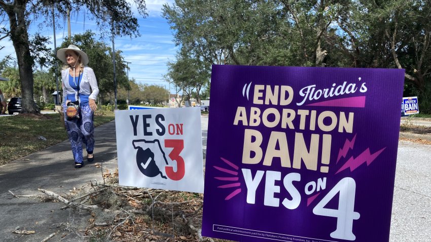 FLORIDA, UNITED STATES – OCTOBER 27: A woman walks by campaign signs at an early voting site at the West Oaks Branch Library in Ocoee, Florida, United States on October 27, 2024. With nine days to go before the November 5 US presidential election, the Florida Department of Elections reports that more than 4 million people in Florida have cast their ballots, either by voting in person at an early voting site or by mail-in ballots. (Photo by Paul Hennesy/Anadolu via Getty Images)