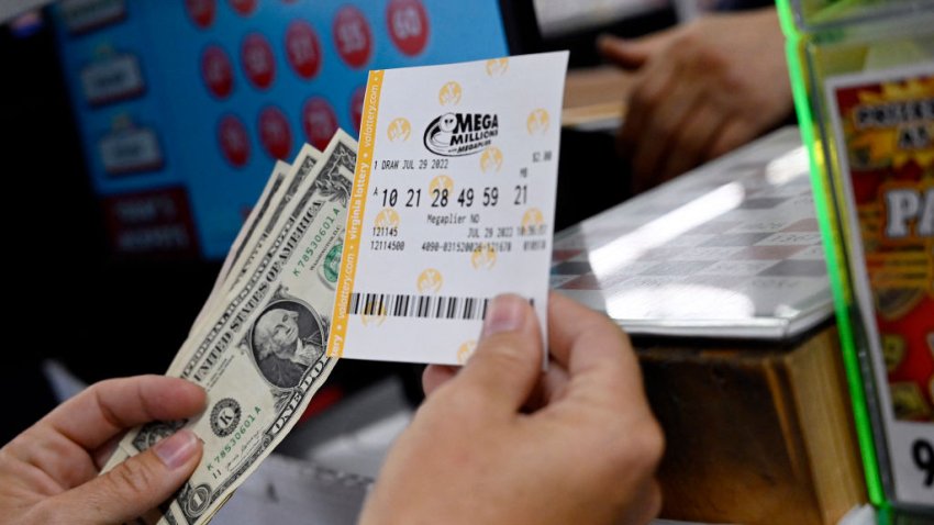 A person buys a Mega Millions lottery ticket at a store on July 29, 2022 in Arlington, Virginia. The jackpot for Friday’s Mega Millions is now $1.1 billion, the second-largest jackpot in game history. (Photo by OLIVIER DOULIERY / AFP) (Photo by OLIVIER DOULIERY/AFP via Getty Images)