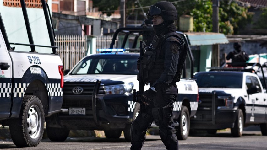 A Veracruz State Police officer stands guard on April 20, 2019 outside the house where thirteen people, including a child, were killed on the eve when a group of unidentified gunmen opened fire on a party in Minatitlan, Veracruz State, Mexico. – The Secretariat of Public Safety said the gunmen arrived at a family reunion in Minatitlan asking to see someone named “El Becky’ — the owner of a local bar — before opening fire killing 13 and injuring hour others. There was no known motive for the shooting, but Veracruz is plagued with organised crime and bloody gun battles frequently erupt between rival drug gangs. (Photo by Angel HERNANDEZ / AFP)        (Photo credit should read ANGEL HERNANDEZ/AFP via Getty Images)