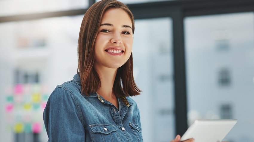 Happy woman, portrait and creative with tablet for data, development or research on agenda at office. Young female person, designer or employee browsing on technology for online startup at workplace