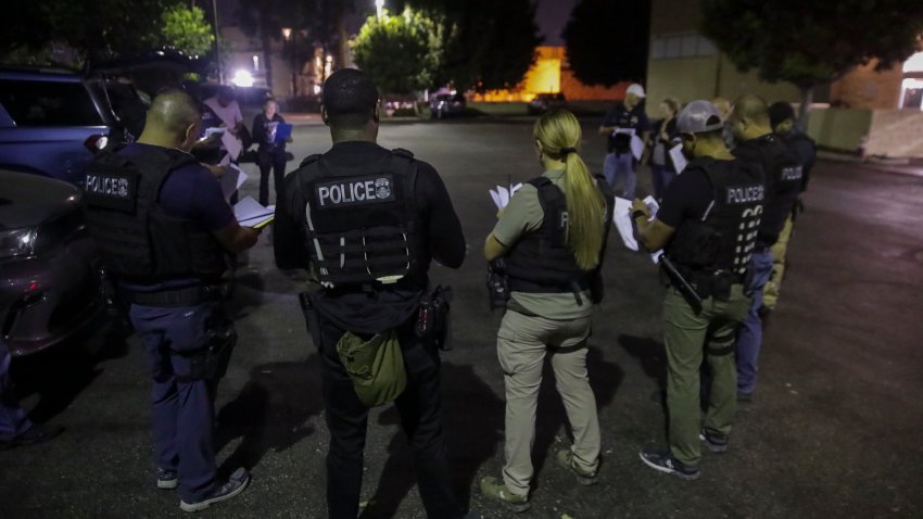 Los Angeles, CA – September 08: Immigration and Customs Enforcement agents huddle in a parking lot before raiding to arrest an illegal immigrant with criminal record on Thursday, Sept. 8, 2022 in Los Angeles, CA. (Irfan Khan / Los Angeles Times via Getty Images)