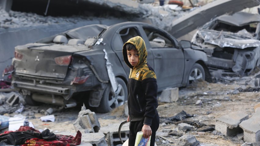 DEIR AL BALAH, GAZA – JANUARY 15: A Palestinian child is seen near the house that was completely destroyed as a result of the Israeli attack on a house belonging to the ‘Shahin’ family in the southern area of Deir al-Balah city in the central Gaza Strip on January 15, 2025. 13 people were killed and several others injured in an Israeli airstrike on a home belonging to the ‘Shahin’ family in the southern area of Deir al-Balah. While the building targeted in the attack was completely destroyed, the cars around it were also damaged and became unusable. (Photo by Ashraf Amra/Anadolu via Getty Images)