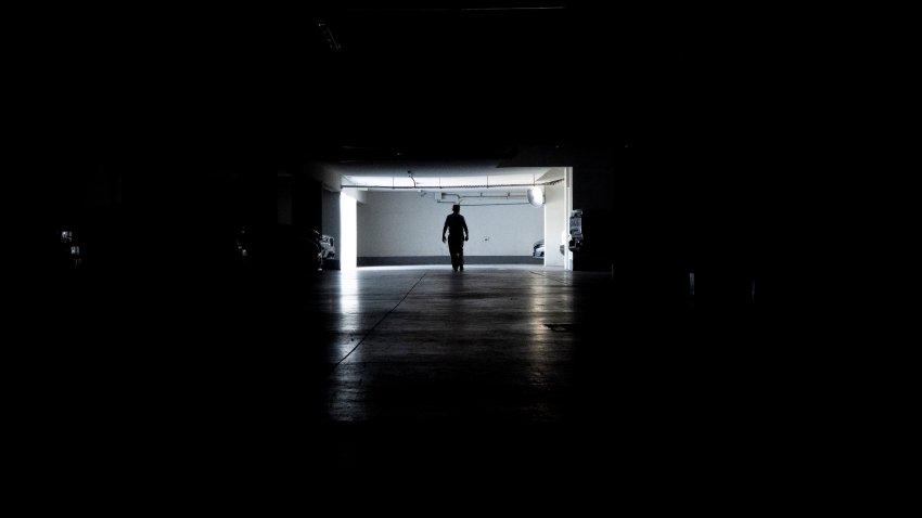 Un hombre camina por un garaje durante un apagón masivo, en Santiago, Chile, el martes 25 de febrero de 2025. (AP Foto/Matías Basualdo)