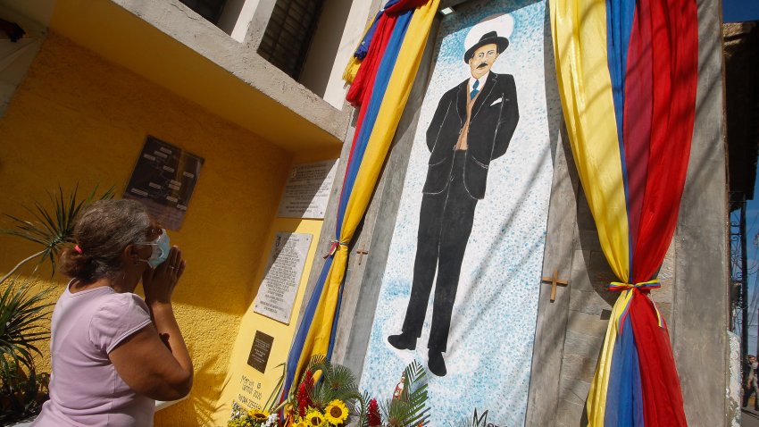 A woman prays in front of a mural of Dr. Jose Gregorio Hernandez prior to the beatification ceremony of the Venezuelan physician in the midst of the Covid-19 pandemic in the La Pastora neighborhood of Caracas, Venezuela on April 30, 2021. (Photo by Javier Campos/NurPhoto via Getty Images)