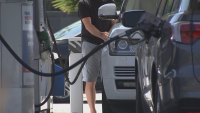 Men fill up their cars with gas at station