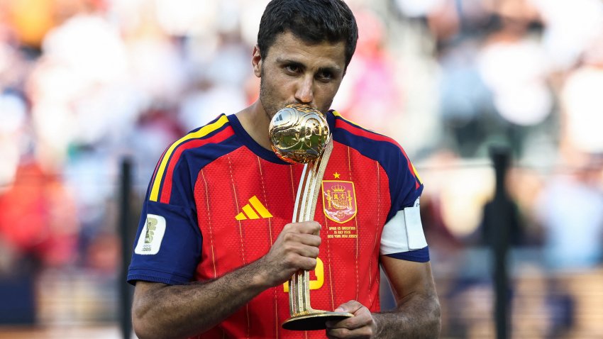 Spain's midfielder #16 Rodri kisses the Golden Ball award.